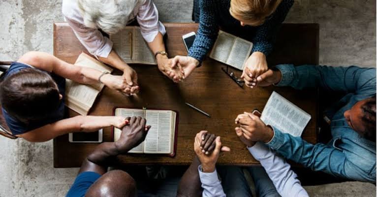 Church staff praying together while meeting
